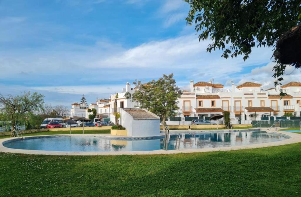 a large swimming pool in a park with buildings in the background at APARTAMENTO EN LOS GALLOS in Chiclana de la Frontera