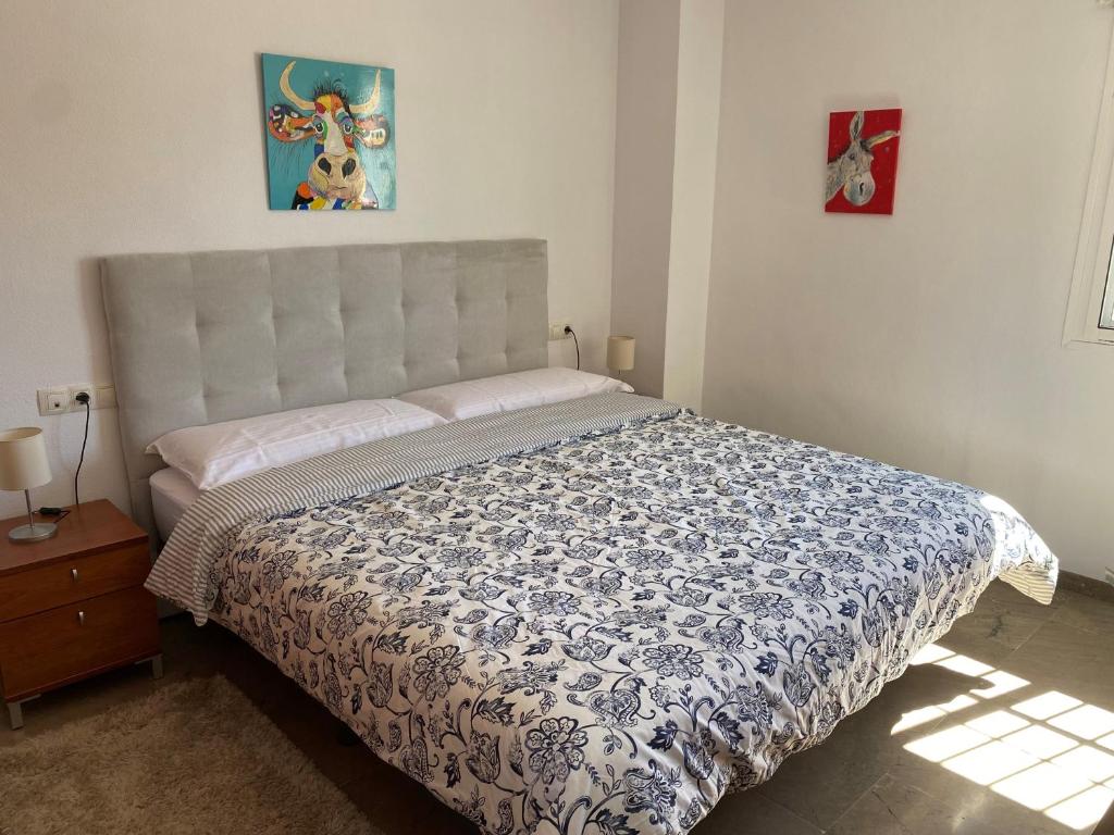 a bedroom with a bed with a blue and white comforter at Casa Balcones - Benalmadena Pueblo in Benalmádena