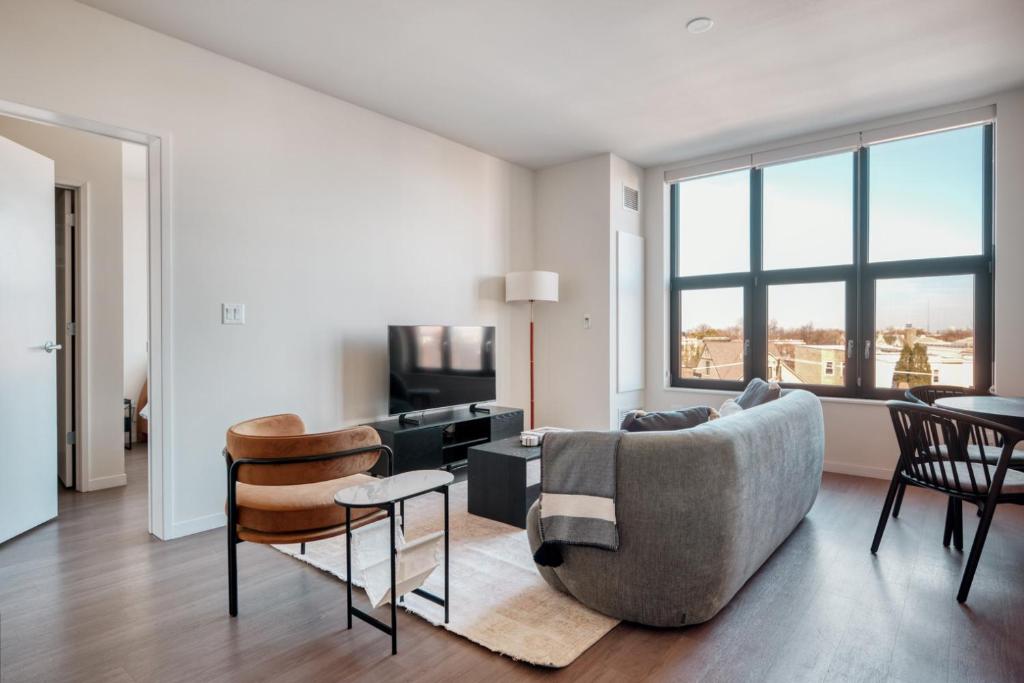 un salon avec un canapé et des chaises dans l'établissement Logan Square 2br w pool lounge gym nr L CHI-869, à Chicago