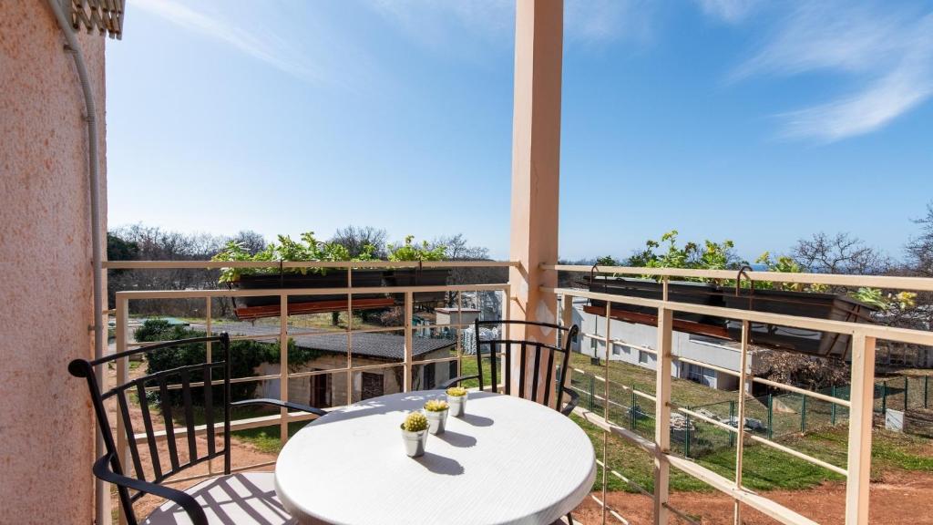 balcón con mesa y vistas al jardín en Apartment Sana with Sea View, en Novigrad Istria