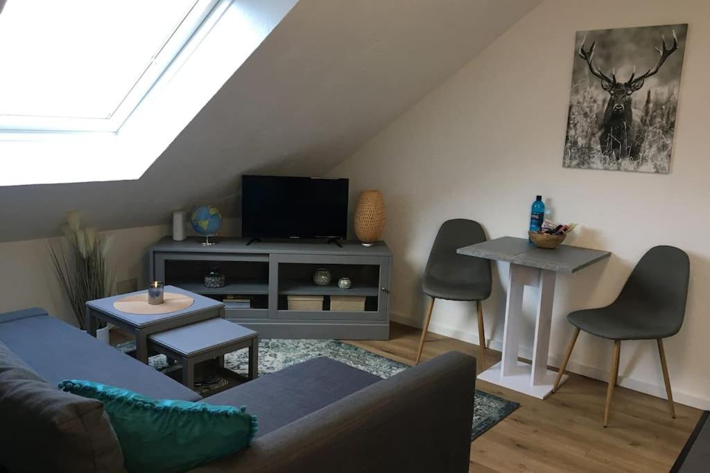 een woonkamer met een bank en een tv bij Gemütliches Apartment am Kurhaus in Dobel in Dobel