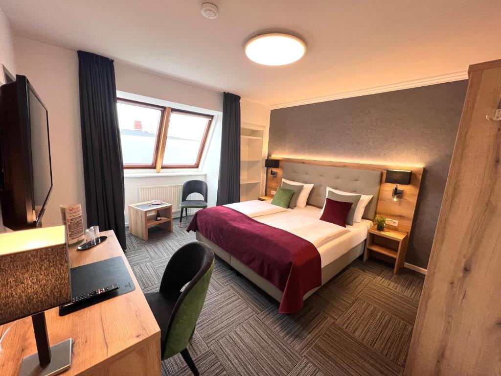 Pokój hotelowy z łóżkiem i biurkiem w obiekcie Hotel Garni am Obsthof GbR w mieście Stade