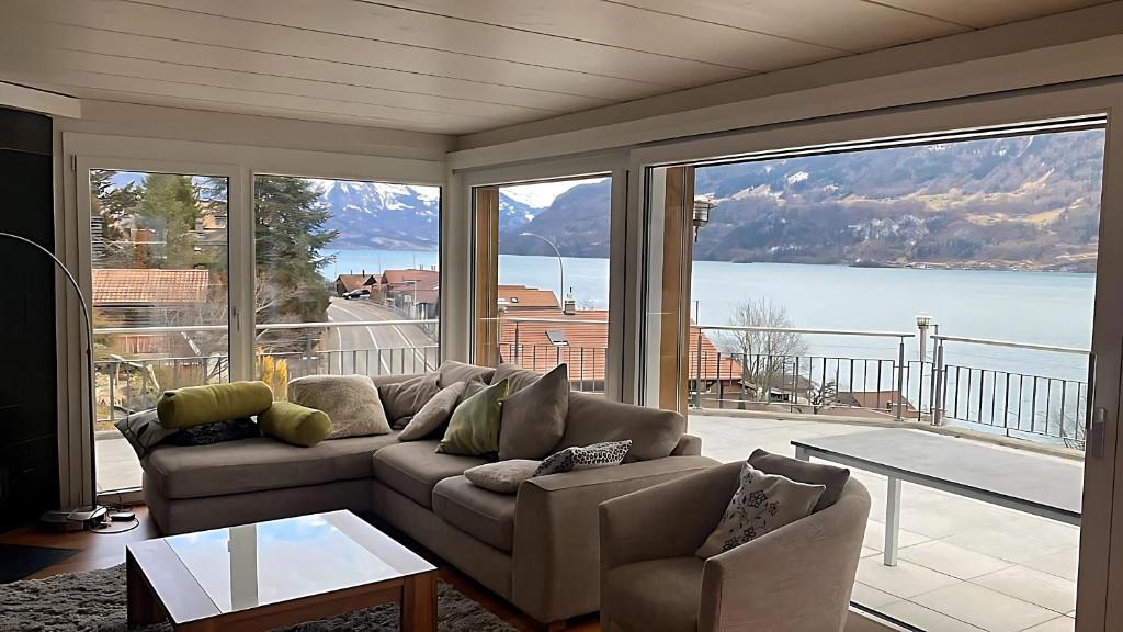 sala de estar con sofá y ventanas grandes en Ultra Luxurious House Lake view en Niederried