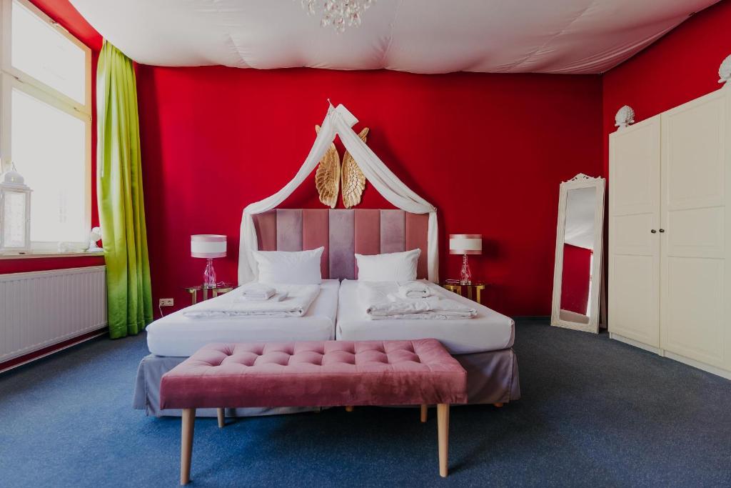 LaLeLu Hostel Dresden في درسدن: غرفة حمراء بسريرين وجدار احمر