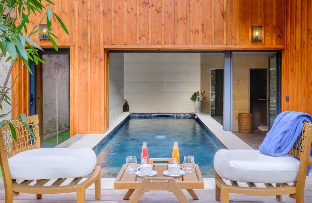 two chairs and a table next to a swimming pool at Le Boutique Hotel & Spa in Bordeaux