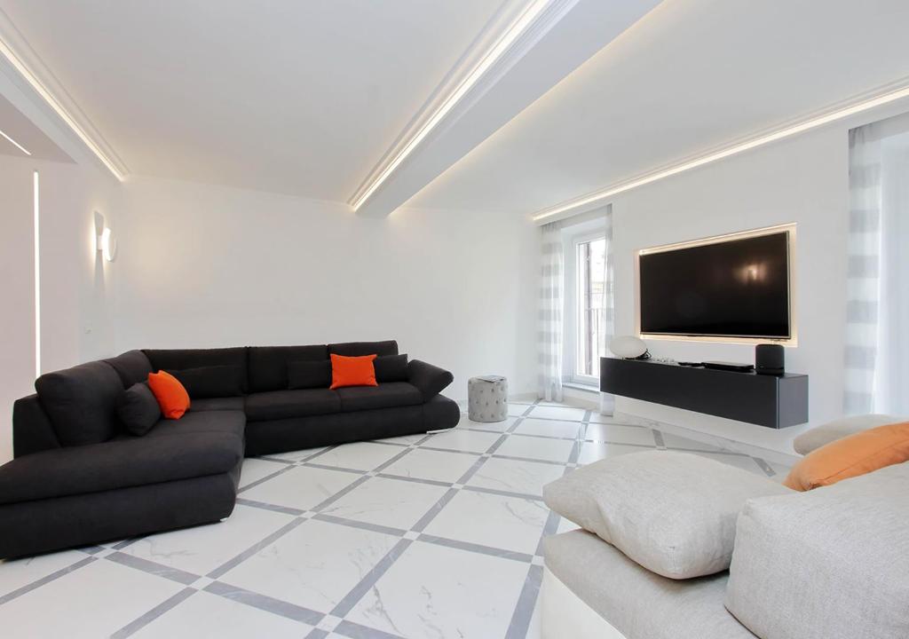 a living room with a couch and a flat screen tv at Exclusive Apartment Spagna View on Spanish Square in Rome