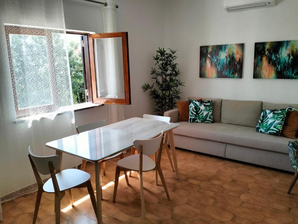 een woonkamer met een tafel en stoelen en een bank bij 2 Quinta Lamy - Casas & Papéis in Porches