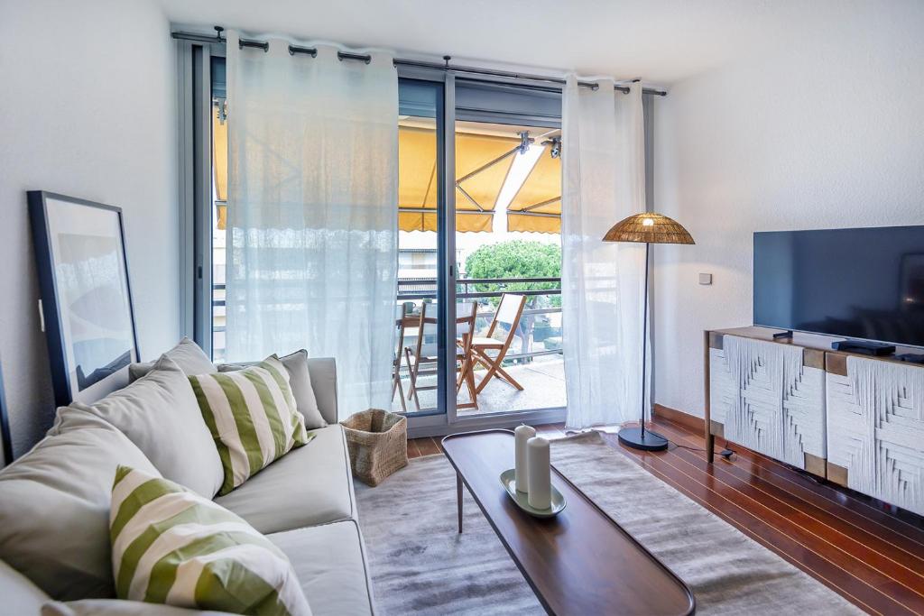 a living room with a white couch and a tv at Residence De Vacance, superb 3 room apartment with in Saint-Laurent-du-Var