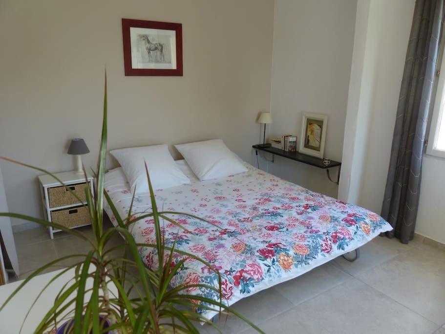 sypialnia z łóżkiem z kwiecistą kołdrą w obiekcie Campagne de Saint Clair w mieście Pertuis