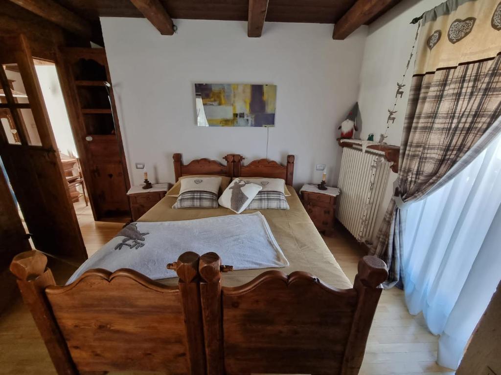 um quarto com uma cama de madeira num quarto em La Peiro Douco em Roure Turin