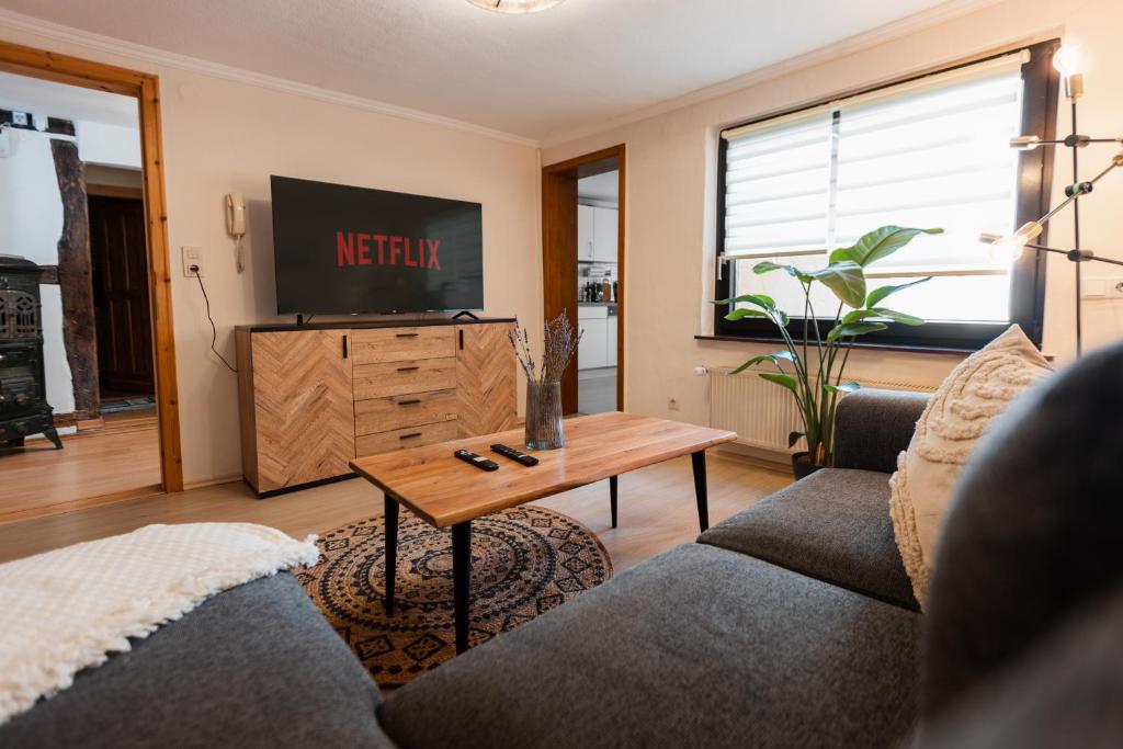 uma sala de estar com um sofá e uma televisão em Charmantes Fachwerkhaus in Ediger-Eller - Nähe Calmont Kletterstieg mit 2 Schlafzimmer, Netflix em Ediger-Eller