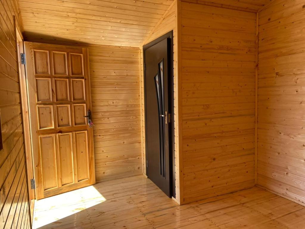 an empty wooden room with an open door at Эко Аура in Areguni