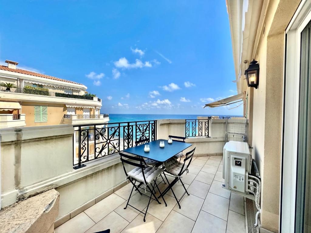 a balcony with a table and chairs and the ocean at "Le Victoria Beach" Vue Mer Plein Centre, Spacieux in Menton