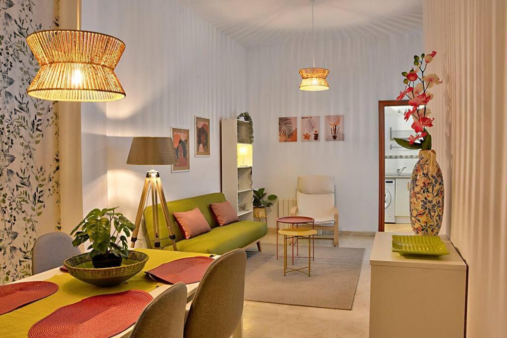 - un salon avec une table et un canapé vert dans l'établissement Apartamento Calle Feria, à Séville