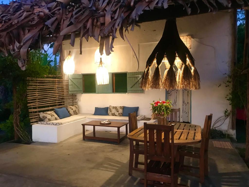 a patio with a couch and a table and chairs at Corto Novo Maison d'hôtes-Camping in Nosy Be
