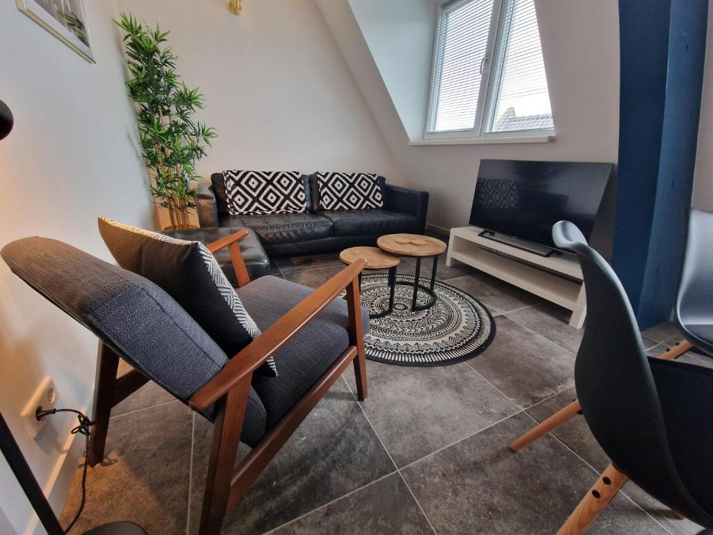 uma sala de estar com duas cadeiras e um sofá em Woonhotel Petruskerk em Vlissingen