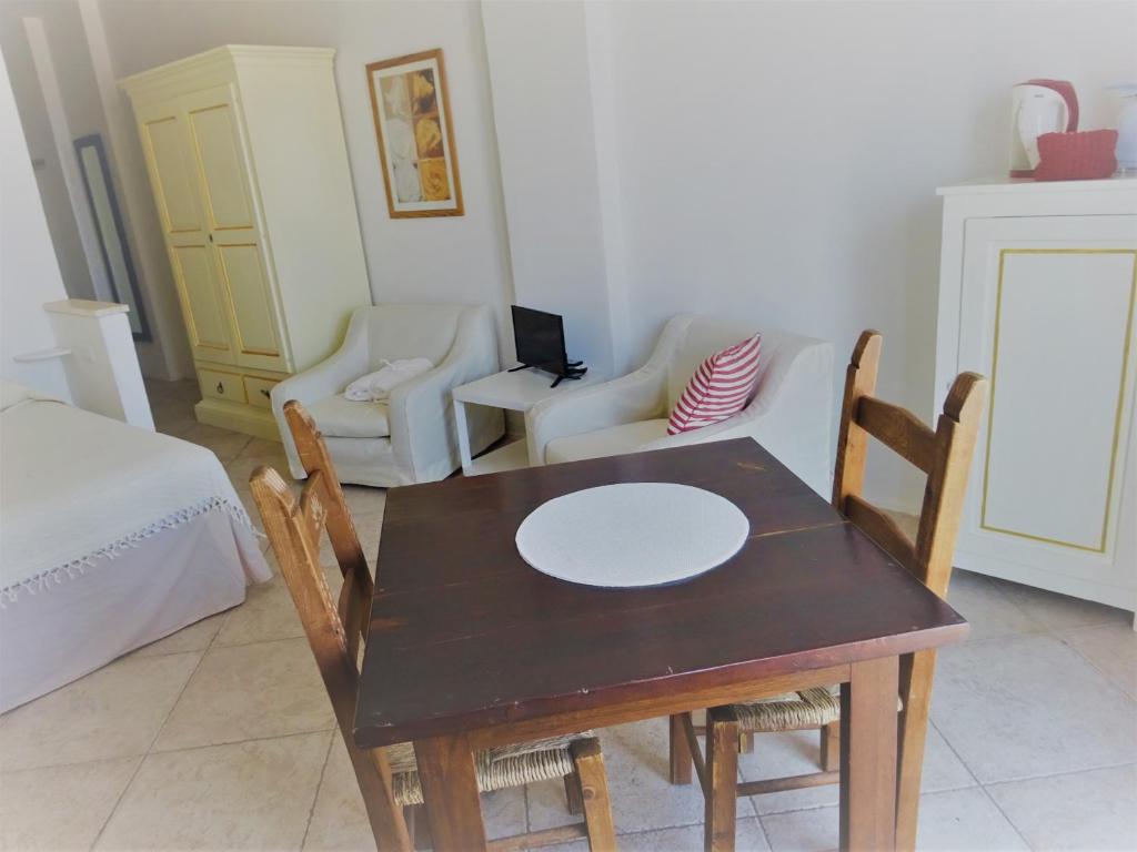 a dining room with a table and chairs and a bed at Red - Monolocale San Pantaleo in San Pantaleo