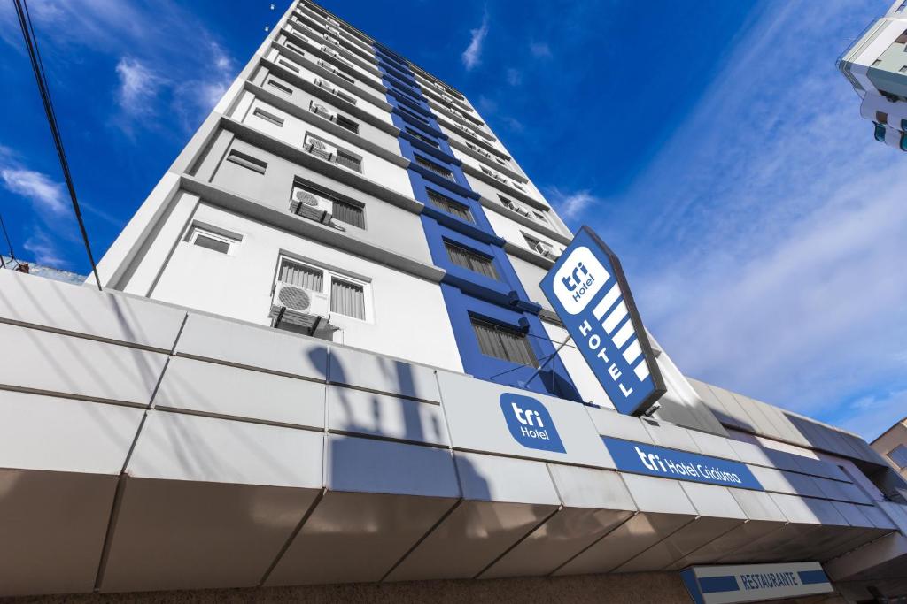 a building with a sign on the side of it at Tri Hotel Criciúma in Criciúma