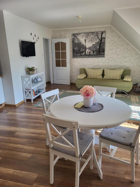 a living room with a white table and chairs at Apartmán pri parku in Seredʼ