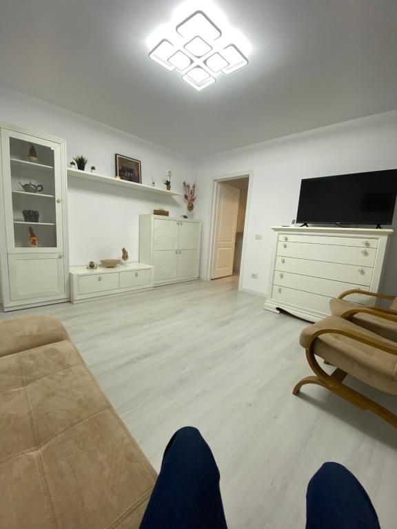 a white living room with a couch and a tv at PH16 in Piatra Neamţ