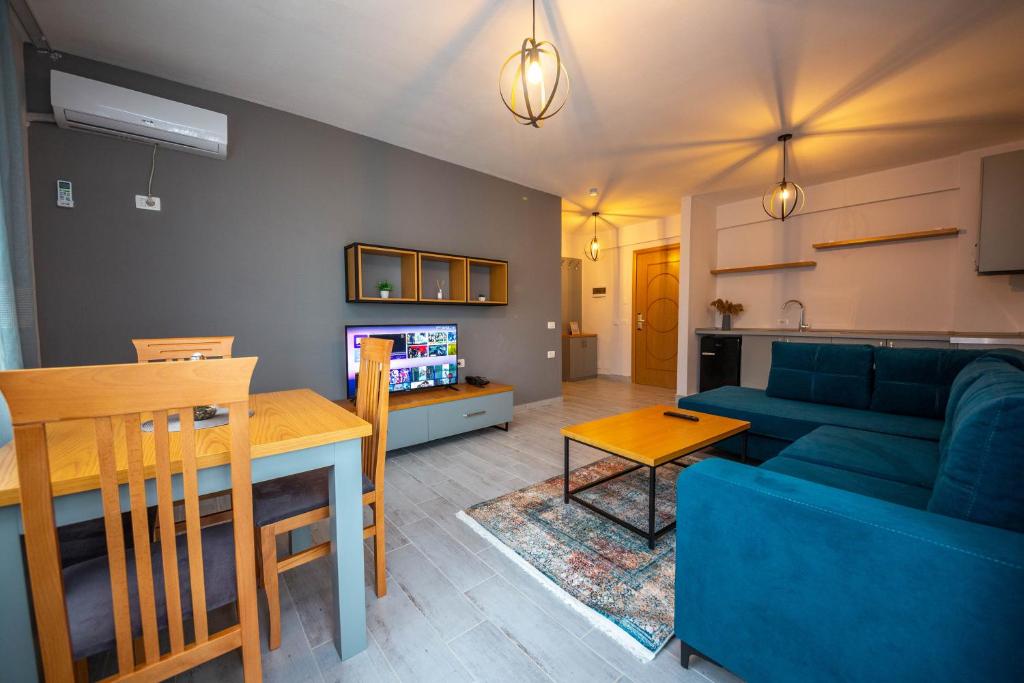 a living room with a blue couch and a table at Aerial Hotel & Spa in Vlorë