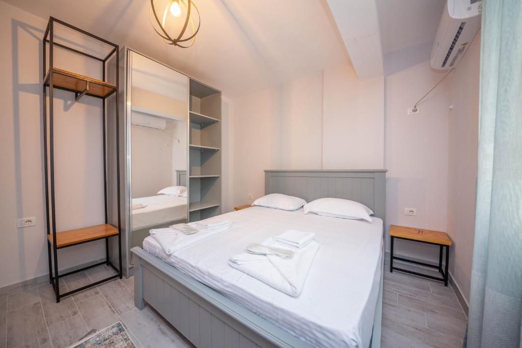 a bedroom with a white bed and a mirror at Aerial Hotel & Spa in Vlorë