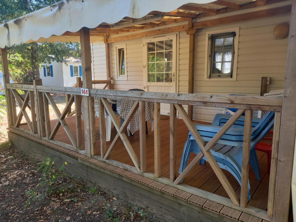 a porch with a wooden fence in front of a house at Mobil home 4 personnes in Saint-Paul-lès-Dax