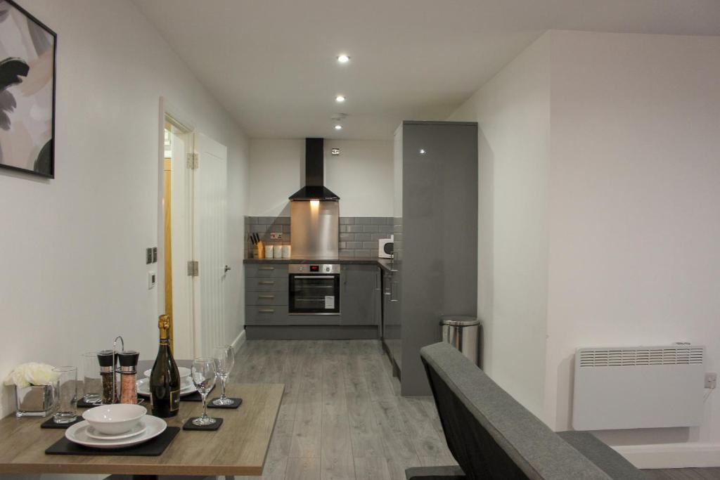 a kitchen with a table and a dining room at Modern Bradford City Apartment in Bradford