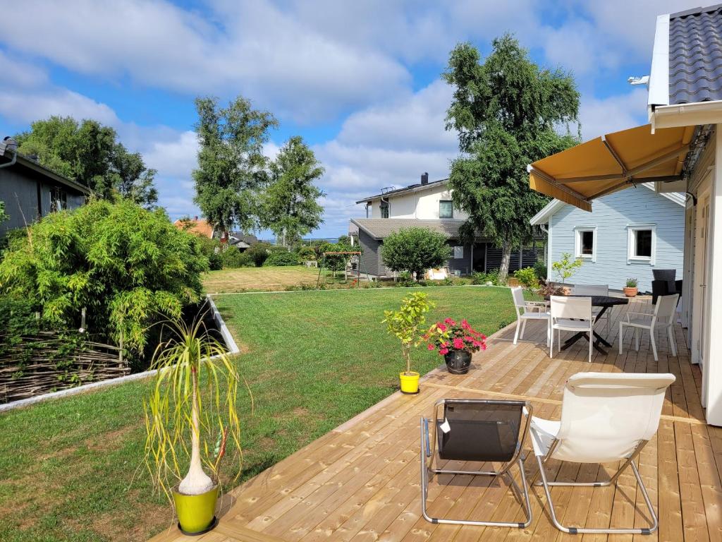 patio trasero con terraza con mesa y sillas en Frillesås BB Vallersvik en Frillesås