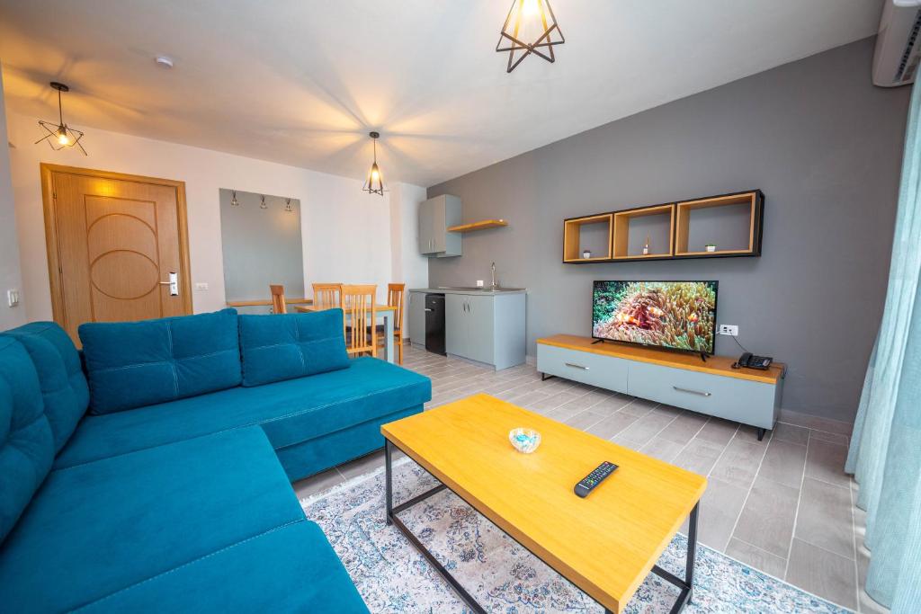 a living room with a blue couch and a table at Aerial Hotel & Spa in Vlorë