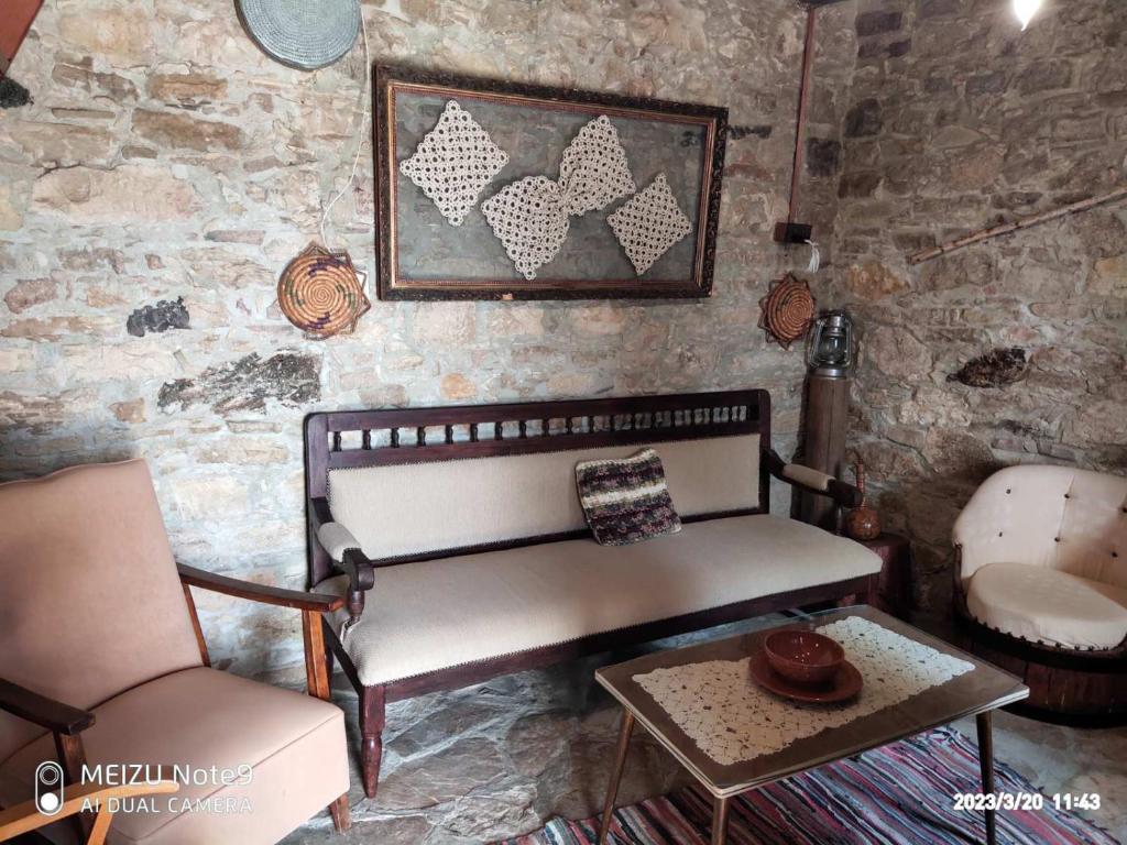 um quarto com um banco, uma cadeira e uma mesa em Angel's Traditional House 