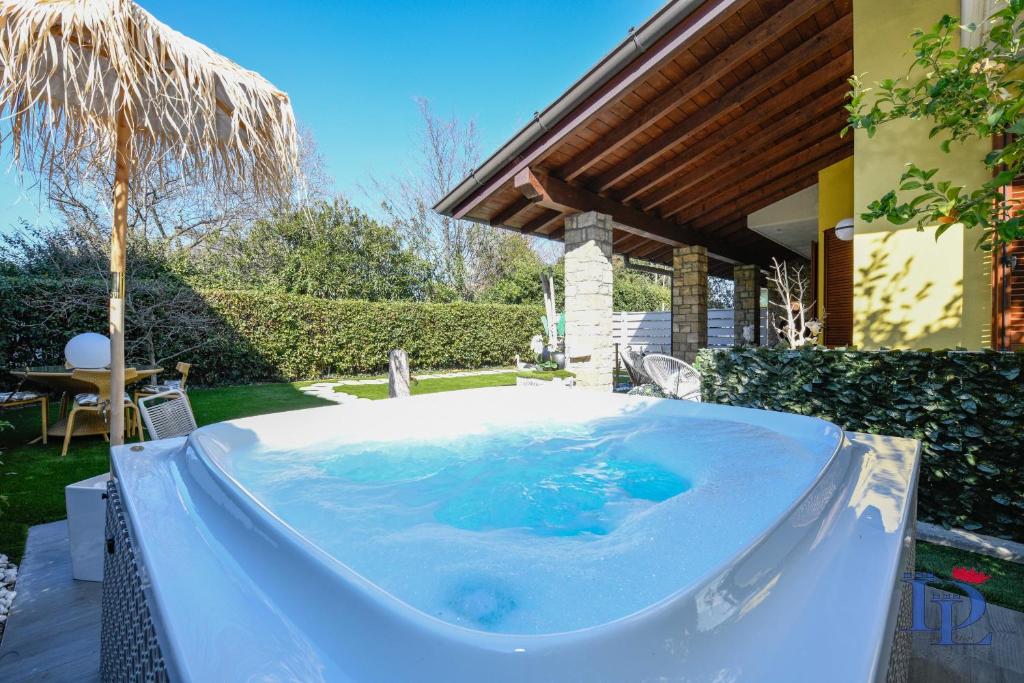 una bañera de hidromasaje en el patio trasero de una casa en DesenzanoLoft Luxury suite with jacuzzi and garden, en Desenzano del Garda