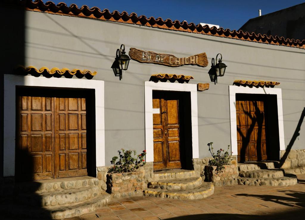 a building with three doors and a sign on it at Hostel Lo de Chichi in Cafayate