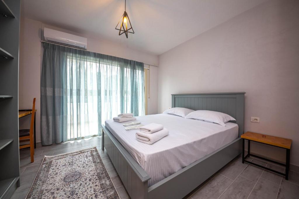 a bedroom with a large bed with towels on it at Aerial Hotel & Spa in Vlorë