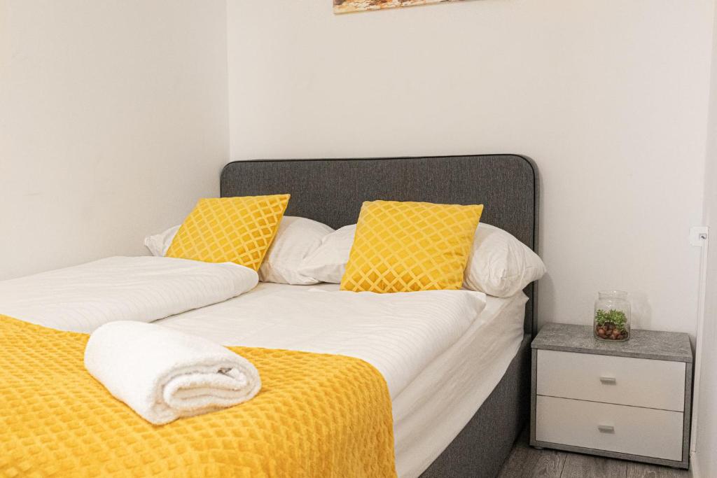 two beds with yellow and white pillows in a bedroom at Standard 3BR/3BA Apt. near Hauptbahnhof in Vienna