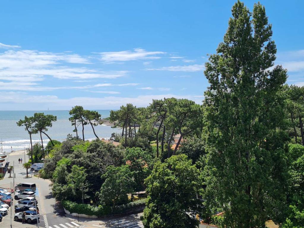 Blick auf einen Parkplatz mit Bäumen und Strand in der Unterkunft Appartement Vaux-sur-Mer, 2 pièces, 4 personnes - FR-1-550-22 in Vaux-sur-Mer