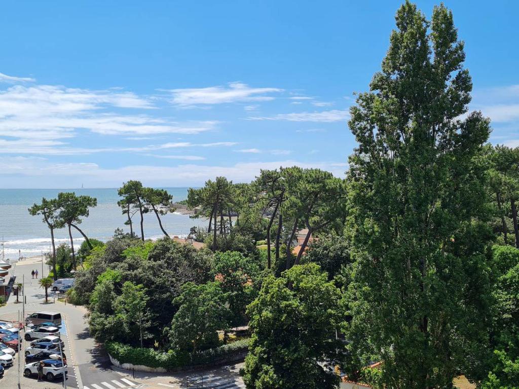 Elle offre une vue sur un parking avec des arbres et une plage. dans l'établissement Appartement T2 à 150m de la plage avec parking - FR-1-550-22, à Vaux-sur-Mer