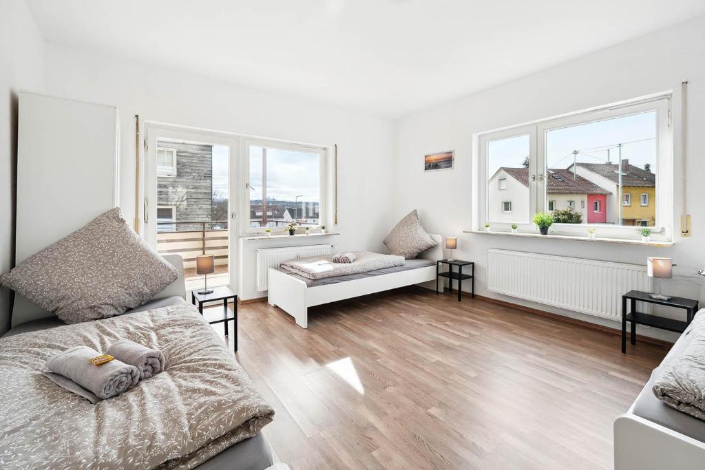 a living room with a bed and two windows at Monteurwohnungen am Neckar in Köngen
