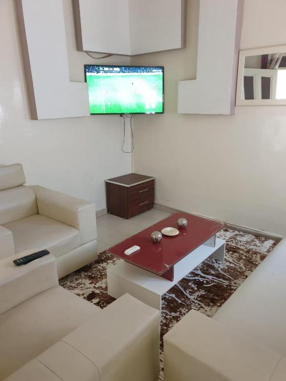 a living room with a couch and a tv at Al Amana in Dakar
