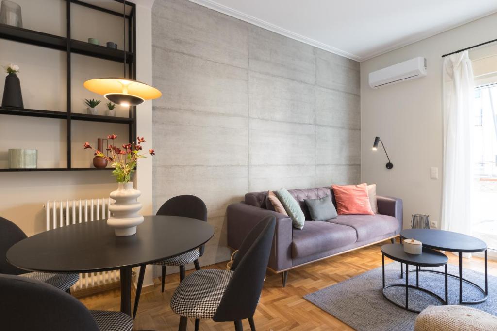 una sala de estar con un sofá y una mesa en Callirhoē Luxury 2BD Acropolis Apartment, en Atenas