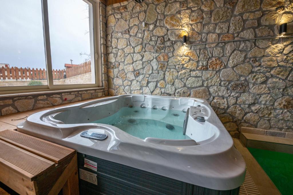 a large bath tub in a room with a window at Aerial Hotel & Spa in Vlorë