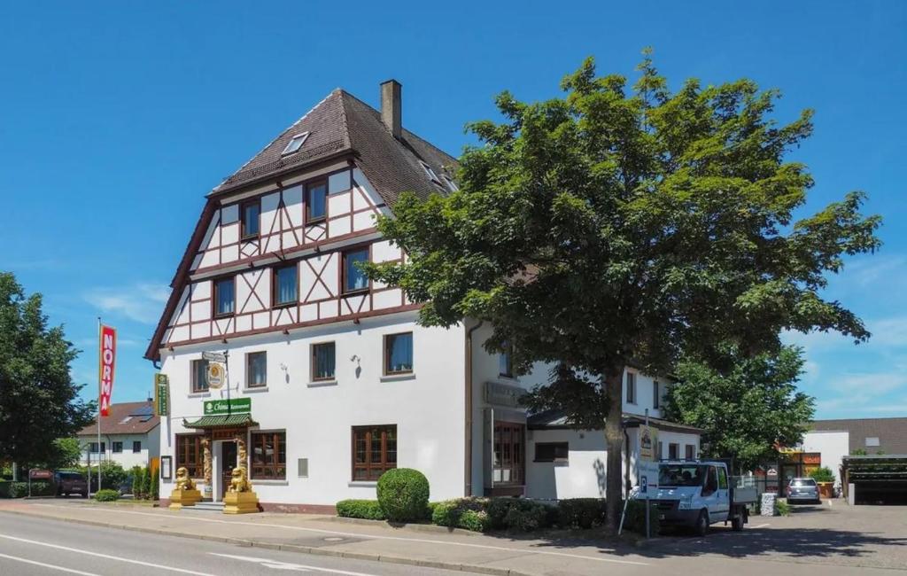 duży biały budynek z drzewem przed nim w obiekcie Hotel Sonnenkeller w mieście Neu-Ulm