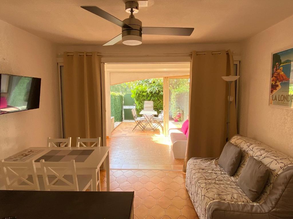 uma sala de estar com um sofá e uma ventoinha de tecto em Les locations Cinaureva ­« L'Argentière » em La Londe-les-Maures