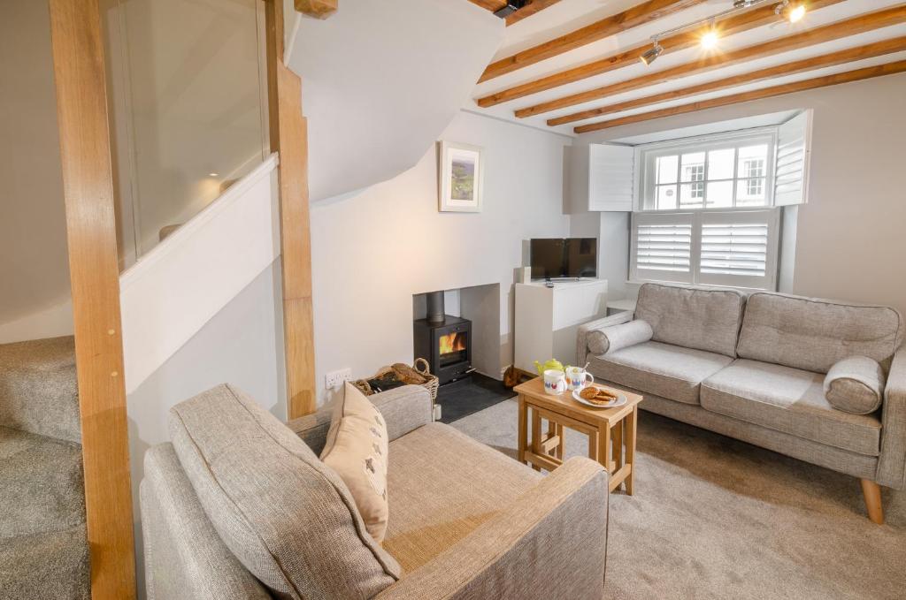 a living room with a couch and a fireplace at Cherry Tree Cottage in Chapel Stile