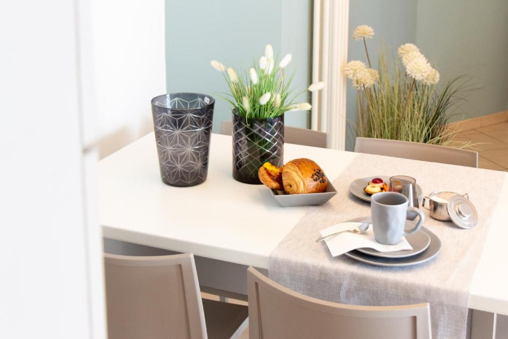 - une table avec une assiette de nourriture et une tasse de café dans l'établissement Residenza Alma, à Riccione