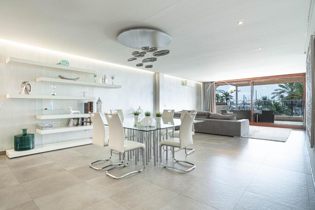 a living room with a dining room table and chairs at GRAND TERRACE APARTMENT in Puerto de Alcudia in Alcudia