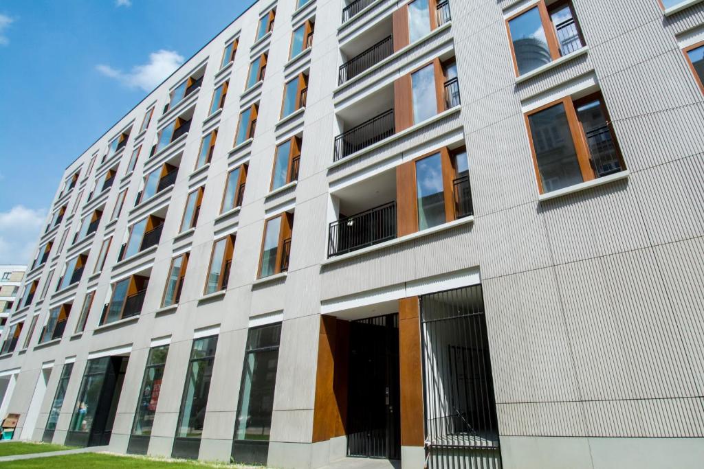 a large white building with a lot of windows at erApartments Browary Warszawskie in Warsaw