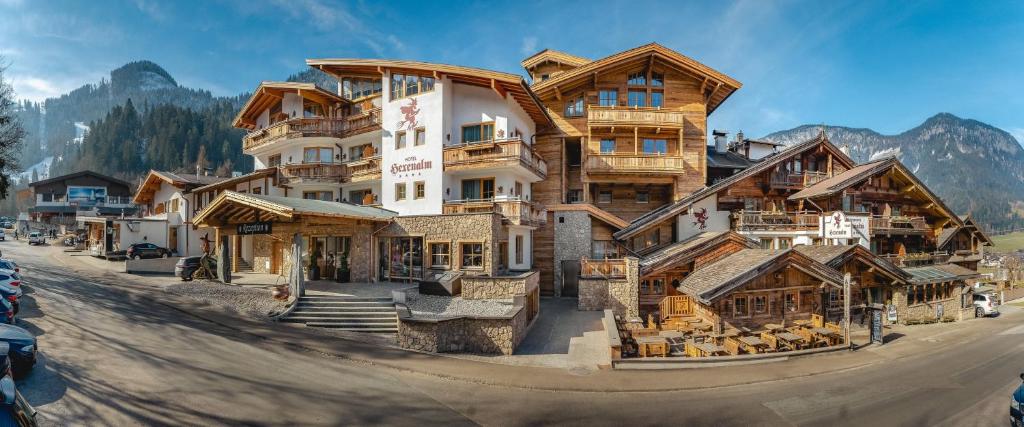 ein großes Holzgebäude in der Mitte einer Straße in der Unterkunft Hotel Restaurant Hexenalm in Söll