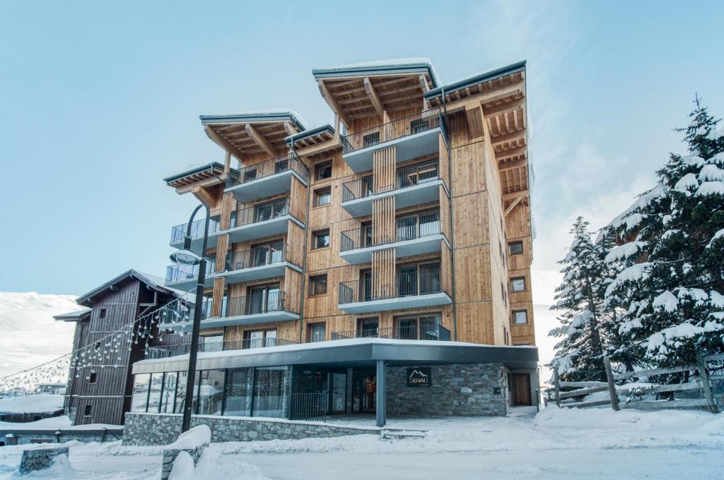 un grand bâtiment avec de la neige devant lui dans l'établissement Residence Denali, à Tignes