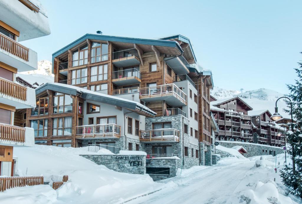 a snow covered street in front of a building at Chalet Hotel Yeti in Tignes